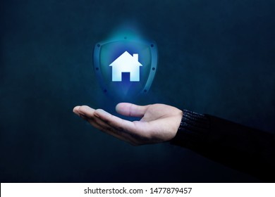 House Or Family Insurance Concept. Company Supporting And Protecting Their Customer By Shield, Home Icon Floating Over A Careful Gesture Hand Of A Businessman