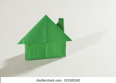 House figure origami over white paper