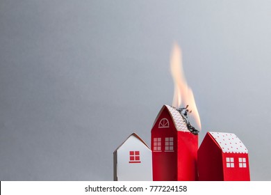 House fire concept. Toy house with flames