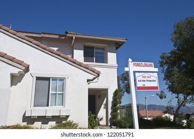 House With Foreclosure Sign Against Blue Sky