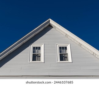 House gable end with single-hung windows against clear blue sky in Boston, MA, USA - Powered by Shutterstock