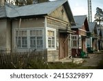 House in ghetto. Poor neighborhood in city. Hut made of planks. Windows in one-storey building.