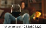 House, glass and wine for alcohol addition at night in living room as stress relief or depression. Person, liquor and alcoholic with beverage or drink for problems, issues and substance abuse