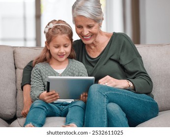 House, grandmother and girl on sofa, tablet and typing with smile, bonding together and care in living room. Family, granny and grandchild with tech, relax and digital app with happiness in lounge - Powered by Shutterstock