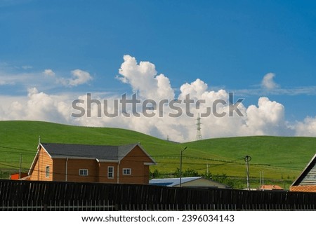 House and grassland hill with beautiful clouds