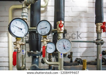 House heating system with many steel pipes, manometers and metal tubes, selective focus
