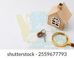 House hunting. Maps, key. magnifying glass and house figure on white table, space for text