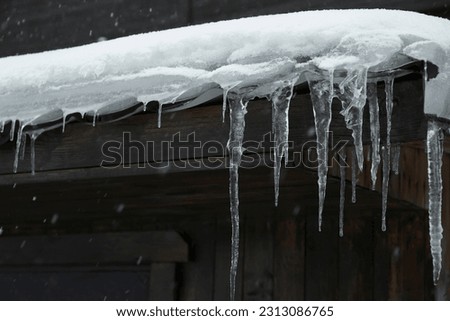 House with icicles on roof. Winter season