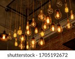 House interior of loft and rustic style. Beautiful vintage luxury light bulb hanging decor glowing in dark. Retro filter effect style. Blend of history and modern.