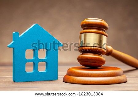 House and judge gavel on brown background. The concept of selling a home cher auction or property section.