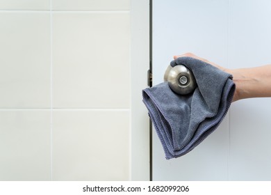 House Keeper Cleaning A Dirty Stainless Door Knob.