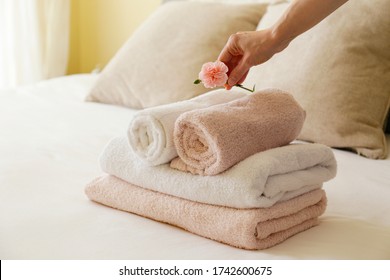 House keeping lady changing the set of folded and stacked towels in hotel room with freshly made bed, perfectly clean and ironed sheets in natural sun light. Close up, copy space for text. - Shutterstock ID 1742600675