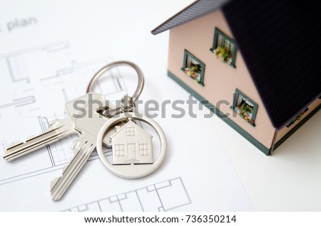 House key on a house shaped pendant. Real estate agent concept on white background