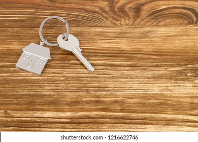 House key on wooden background concept for mortgage