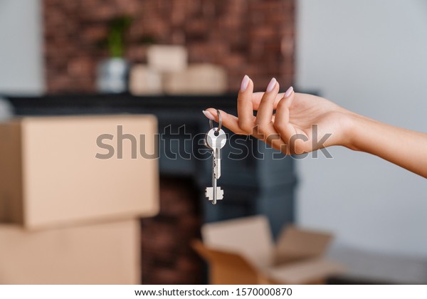 House key in womans hands, concept of moving\
or rent appartment