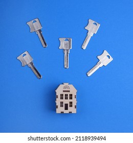 House Keys And A Miniature Model Of A European House On A Colored Background. Top View, Flat Lay. The Concept Of Buying A Home.