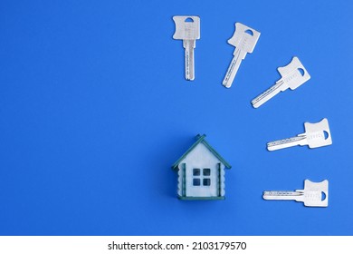 House Keys And Miniature House Model On A Colorful Bright Background. Top View, Flat Lay. Home Buying Concept.