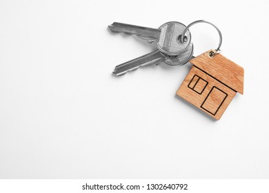 House Keys With Trinket On White Background, Top View. Space For Text