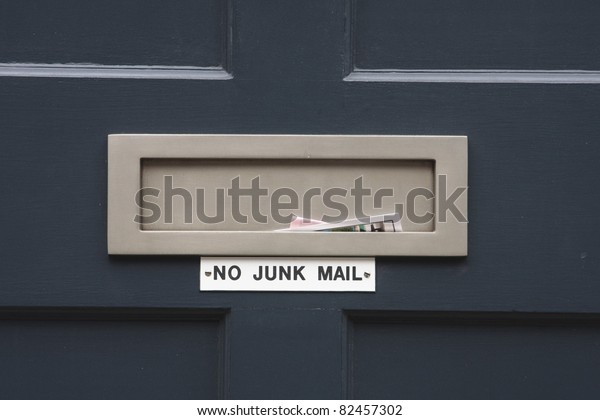 House\
letterbox with \'No junk mail\' sign and junk\
mail