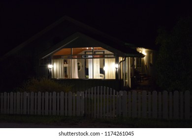 House With Lights During Night And White Wooden Fence Around The Property - Norway Norwegian