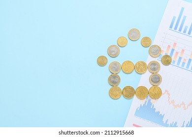 House made of coins and diagrams on blue background