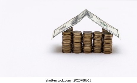 House made with coins and a roof of dollar bills