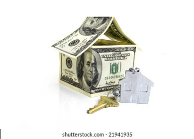 house made from hundred dollar bills and a key isolated against white background