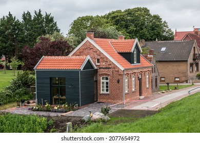House made of red clincker bricks surrounded by green trees