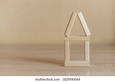 House made of wooden blocks on a neutral background - Shutterstock ID 1829590064