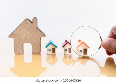 House and magnifying glass for search and explore real estate, houses, apartments for investment. Risks from Interest rate,buy,sell, or leasing in real estate. Solutions to household debt problems.