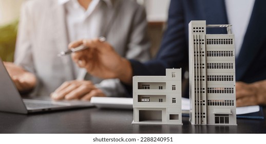House model with agent asking costumer for contract to buy, get insurance or loan real estate or property. - Shutterstock ID 2288240951