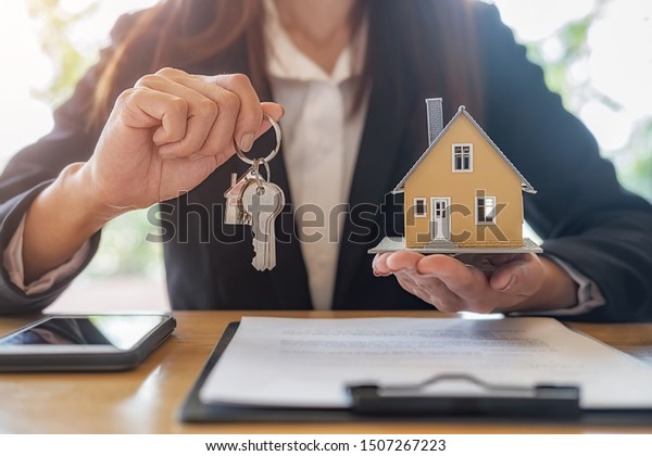 House model with agent and customer\
discussing for contract to buy, get insurance or loan real estate\
or property background.