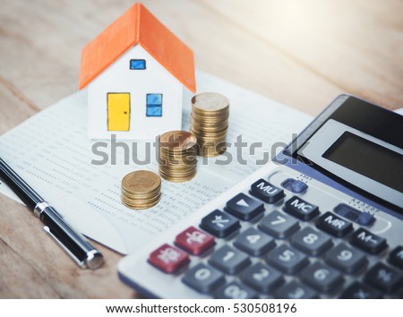 House model and coin on Bank account ,calculator on table for finance ,banking concept.