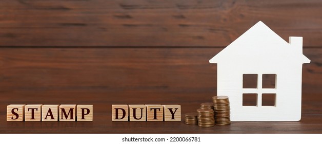 House Model, Cubes With Text Stamp Duty And Coins On Wooden Background. Banner Design