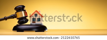 House Model With Gavel On Wooden Table In Courtroom