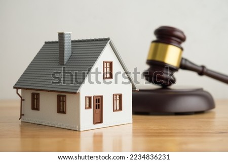 House model, hammer judge gavel on wooden table with white wall background. Foreclosure, bankruptcy concept. Person is unable to repay outstanding debts or obligations, stops mortgage payment.