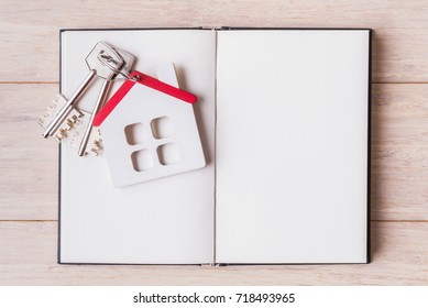 House Model With Keys Over Open Blank Sketchbook.