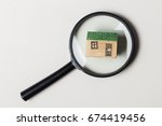 House model with magnifying glass. Property search concept