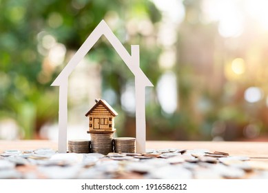 house model on money coins saving for concept investment mortgage finance and home loan refinance