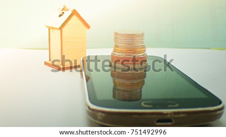 The house model on the smartphone is saving money and business online in technoloye network, Inspiration to the accumulation of money in banks.