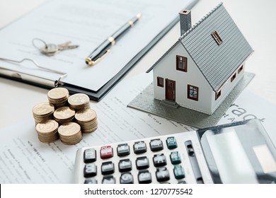 Hausmodell mit Immobilienmaklern und Kunden, die über den Kauf von Immobilien-, Versicherungs- oder Darlehensgrundlagen diskutieren.