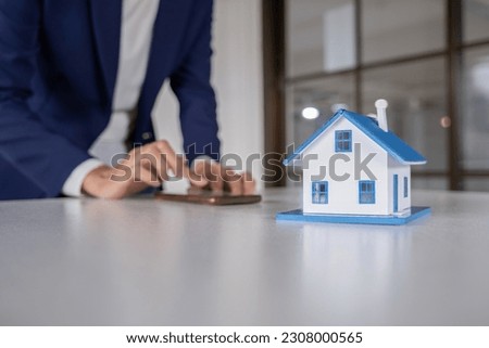House model with real estate agent and customer discussing for c