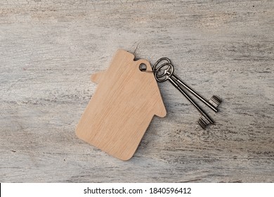house modell with keys on wooden background