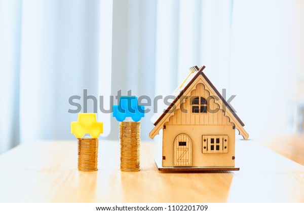House models and car model and gold coins placed\
on wooden boards.Have a background office.Credit or loan and\
earning for home in the family.Use money to exchange or buy in\
business and Real Estate.