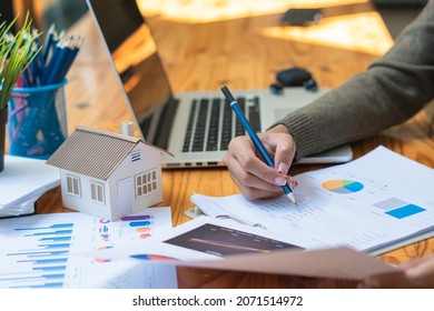 House models, real estate tycoons are analyzing earnings through data analytics graphs. - Shutterstock ID 2071514972