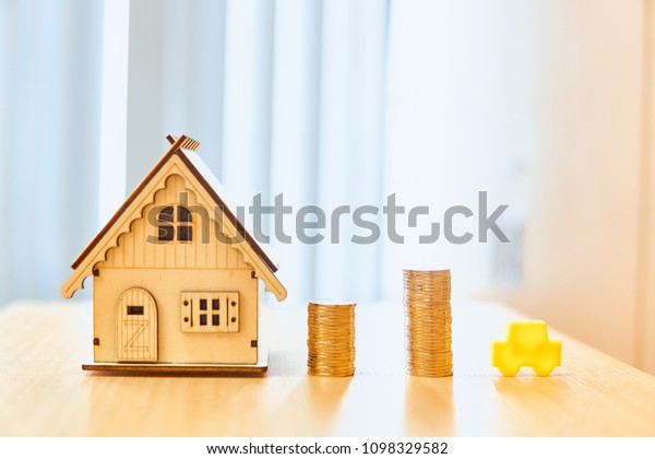  House models and red car models and gold coins placed
on wooden boards.Credit or loan for home and car in the family.Use
money to exchange or buy in business and real estate.              
        