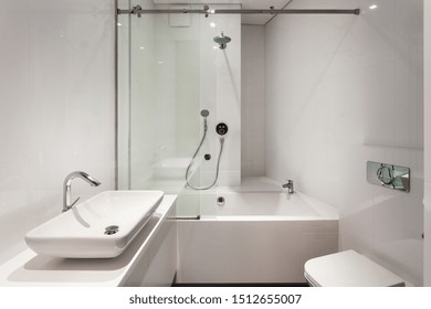 House With Modern Interior Design In Bathroom. White Toilet, Basin And Shower In Room With Loft Style In New Apartment