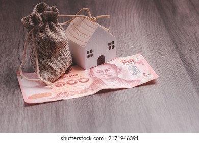 House money bags and small banknotes. Ideas for saving money to buy a house for the future.