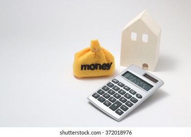 House and money beside calculator