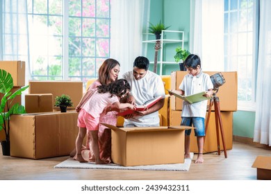 House move concept. Happy Indian young family sitting on the floor in new home - Powered by Shutterstock